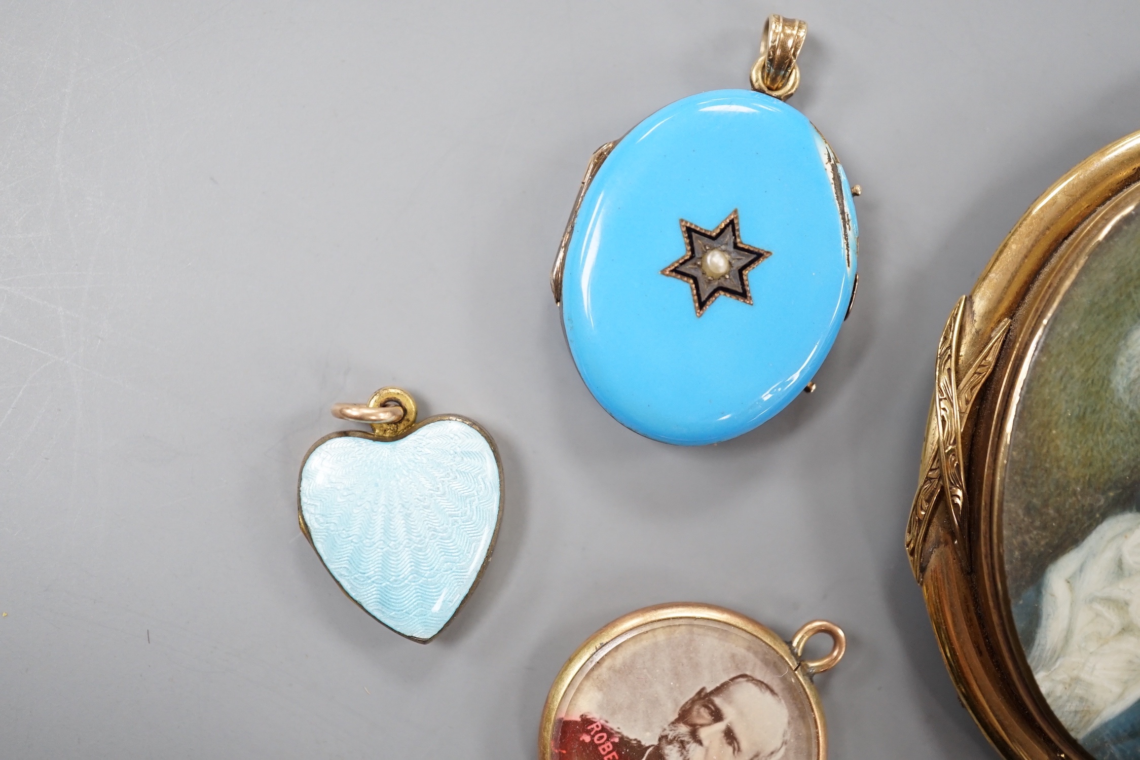 A 19th century yellow metal miniature oval portrait mourning brooch, 54mm, two enamelled lockets(a.f.) and one other small pendant.